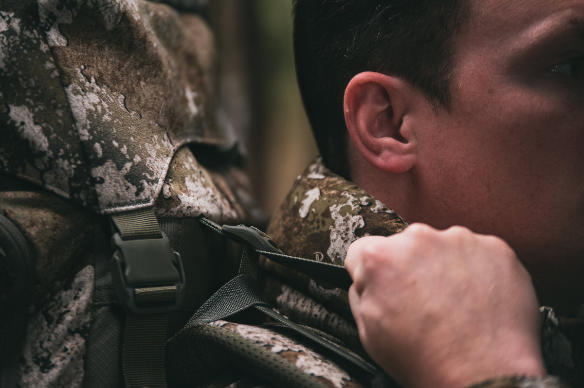 Bowhunter adjusting a quiet hunting pack before an early-season hunt